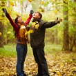 Autumn - Happy couple enjoying falling leaves